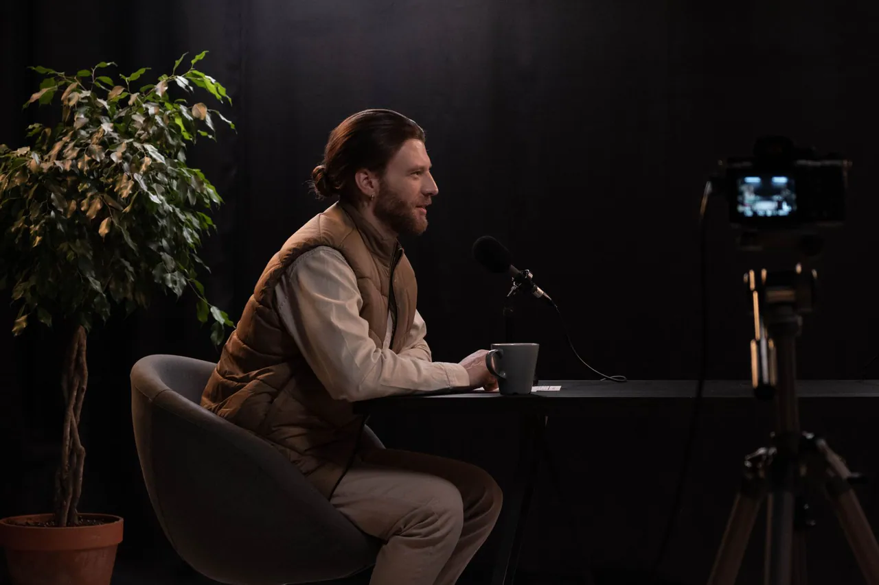 A creator recording a talking-head video in a home studio with a camera and lights